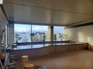 a large swimming pool in a building with a large window at Hiroshima no Yado Aioi in Hiroshima