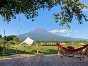 a hammock on a deck with a mountain in the background at MT. FUJI SATOYAMA VACATION in Fujinomiya