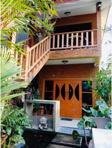 ein Haus mit einer Holztür und einem Balkon in der Unterkunft Golf House in Ban Bang Phai