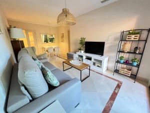 ein Wohnzimmer mit einem Sofa und einem TV in der Unterkunft PUSHE Playa Granada Beach & Golf 11 in Motril