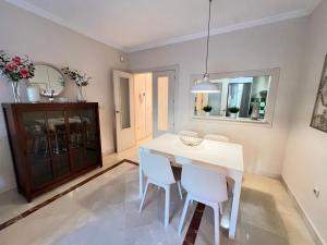 モトリルにあるPUSHE Playa Granada Beach & Golf 11の白いテーブルと椅子のあるダイニングルーム
