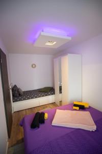 Schlafzimmer mit einem lila Bett und einem Spiegel in der Unterkunft Apartmani Remete in Zagreb