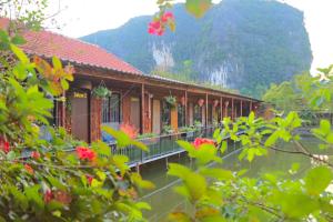 un bâtiment avec des fleurs devant une montagne dans l'établissement Tam Coc Garden Homestay, à Ninh Binh
