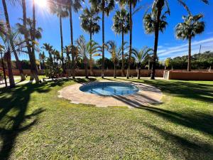 een zwembad in een park met palmbomen bij PUSHE Playa Granada Beach & Golf 11 in Motril