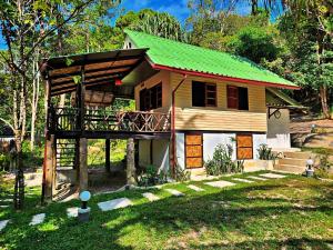 a small house with a green roof at Flower Power Farm Village in Ko Phayam