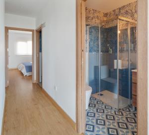 a bathroom with a glass shower and a bedroom at Balcón de Gijón Apartamentos Boutique in Gijón +65 photos