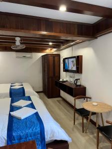 ルアンパバーンにあるNamKhan Riversideのベッドルーム(ベッド1台、テーブル、テレビ付)
