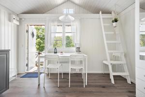 a white dining room with a white table and chairs at First Camp Nickstabadet-Nynäshamn in Nynäshamn