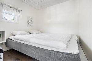 a bed in a room with white walls and a window at First Camp Nickstabadet-Nynäshamn in Nynäshamn