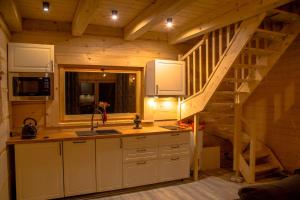 a kitchen with a staircase in a log cabin at Domek Wilk w Górach Sowich in Jugów