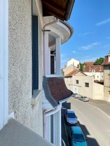 - un balcon dans un immeuble avec une voiture dans une rue dans l'établissement LE VIKING DOUILLET - Proche Thermes & Parcs - Parking à 50m, à Vichy