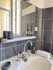 une salle de bain avec un lavabo et un miroir dans l'établissement LE VIKING DOUILLET - Proche Thermes & Parcs - Parking à 50m, à Vichy 33 autres photos