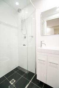 a white bathroom with a shower and a sink at CBD#UnitB Greenland3 Darling Harbour in Sydney