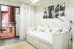 a white bedroom with a large bed and a window at CBD#UnitB Greenland3 Darling Harbour in Sydney
