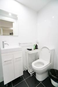 a white bathroom with a toilet and a sink at CBD#UnitB Greenland3 Darling Harbour in Sydney