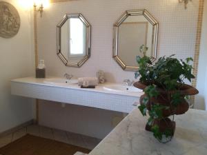 a bathroom with two sinks and two mirrors at Maison d'hôtes Urbegia in Ascain