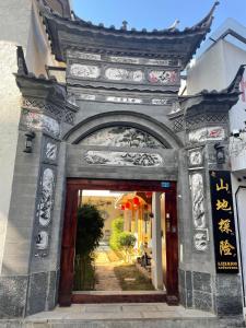una entrada a un edificio con un arco en Lijiang Adventure Inn, en Lijiang