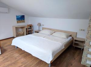 a bedroom with a white bed and a brick wall at Apartment in Lopar with sea view, terrace, air conditioning, washing machine 593-3 in Lopar