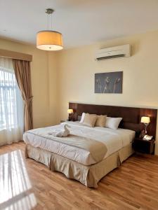 a bedroom with a large bed and a large window at Weekdays Hotel in Muscat