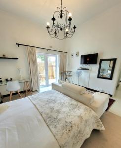 a living room with a white bed and a chandelier at B&B on Buckingham in Johannesburg