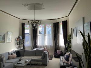 a living room with a couch and a chandelier at Chelsea House Bed & Breakfast in Whangarei