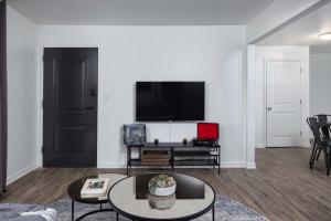 a living room with a tv and a table at The Vibe at Marathon Apartment Suites in Nashville