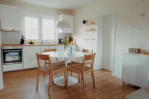 eine Küche mit einem weißen Tisch und Stühlen in einem Zimmer in der Unterkunft Am Deich 13 in Zingst
