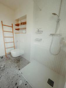 a white bathroom with a toilet and a shower at Am Deich 13 in Zingst