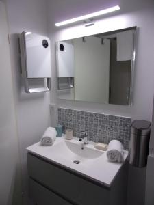 y baño con lavabo y espejo. en Duplex with loggia and view on the golf of Moliets, en Moliets-et-Maa