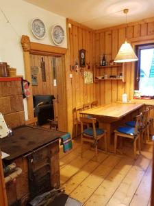 een keuken met een houten tafel en stoelen en een eetkamer bij Stara chałupa in Murzasichle