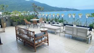 a patio with chairs and tables and a view of the water at Dan Oasis Hotel and Apartment in Danang