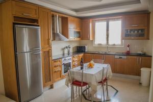 a kitchen with a table and a stainless steel refrigerator at Villa Zenovia in Heraklio