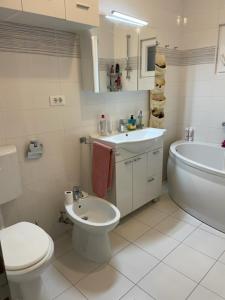 biała łazienka z toaletą i umywalką w obiekcie Island Šolta Comfort apartment Modesty w mieście Nečujam +33 zdjęcia