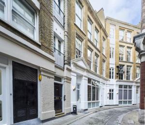 a row of buildings on a street at Clockwork London Flats in London