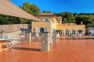 ein Haus mit einer Terrasse mit einem Tisch und Stühlen in der Unterkunft Villa Le Tore in Sorrent