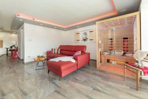 a living room with a red couch and a table at Holiday House Vikend in Polzela +33 photos