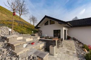 a home with a stone patio and a house at Holiday House Vikend in Polzela