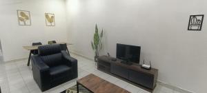 a living room with a chair and a television at Homestay Sofiyyah 1 in Temerloh