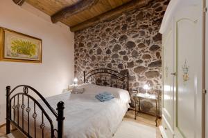 a bedroom with a bed and a stone wall at Antica dimora in Paulilatino