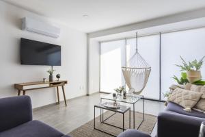 ein Wohnzimmer mit einem Sofa und einem Kronleuchter in der Unterkunft Central Balbuena Apartments in Guadalajara