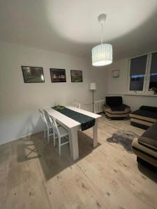 een woonkamer met een witte tafel en stoelen bij Apartament Arverso in Bolesławiec
