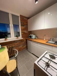 a kitchen with a stove and a counter top at Apartament Arverso in Bolesławiec