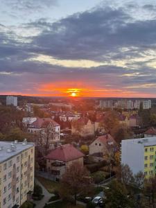 een uitzicht op een stad met de zonsondergang op de achtergrond bij Apartament Arverso in Bolesławiec