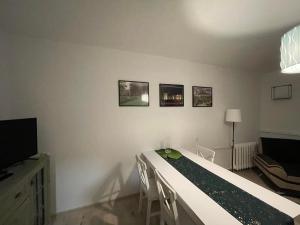 a bedroom with a bed with chairs and a television at Apartament Arverso in Bolesławiec