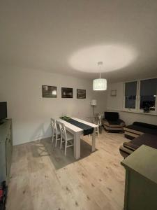 a living room with a table and chairs in it at Apartament Arverso in Bolesławiec