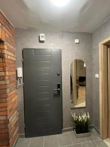 a black door in a room with a mirror at Apartament Arverso in Bolesławiec