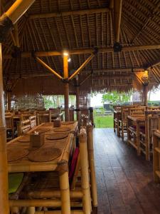 - une grande table en bois dans un restaurant avec des chaises dans l'établissement Rinjani Beach Eco Resort, à Tanjung