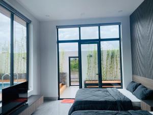 a bedroom with two beds and a large window at Ri Rot villa - Venuestay in Quy Nhon