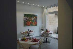 un comedor con 2 mesas y un cuadro en la pared en Dear Mary B&B, en San Cesario di Lecce