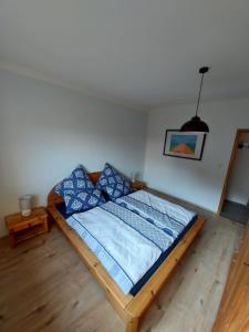 um quarto com uma cama com almofadas azuis em Ferienhaus Berghof Usch 